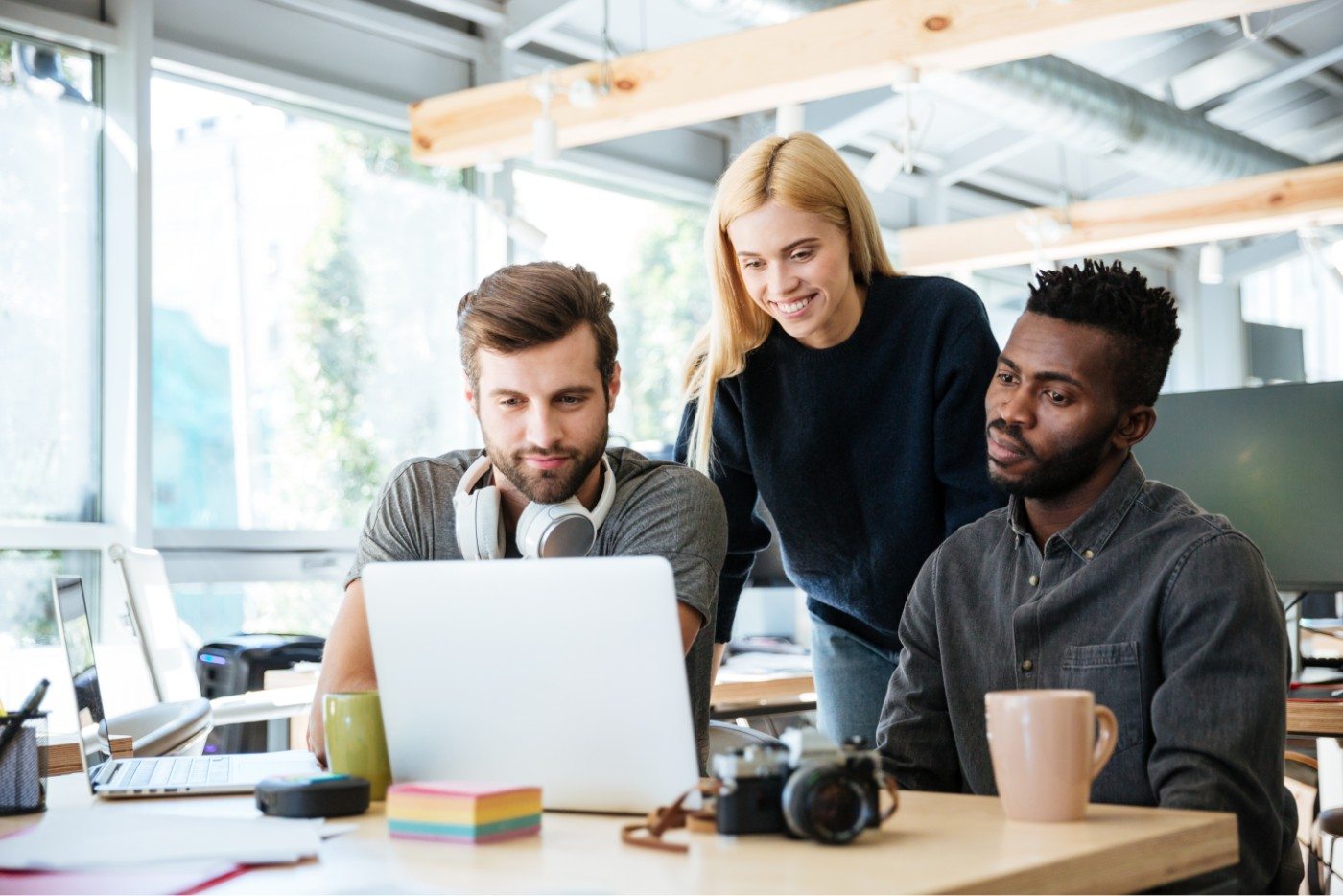 happy-colleagues-sitting-in-office-coworking-PHYA6TG