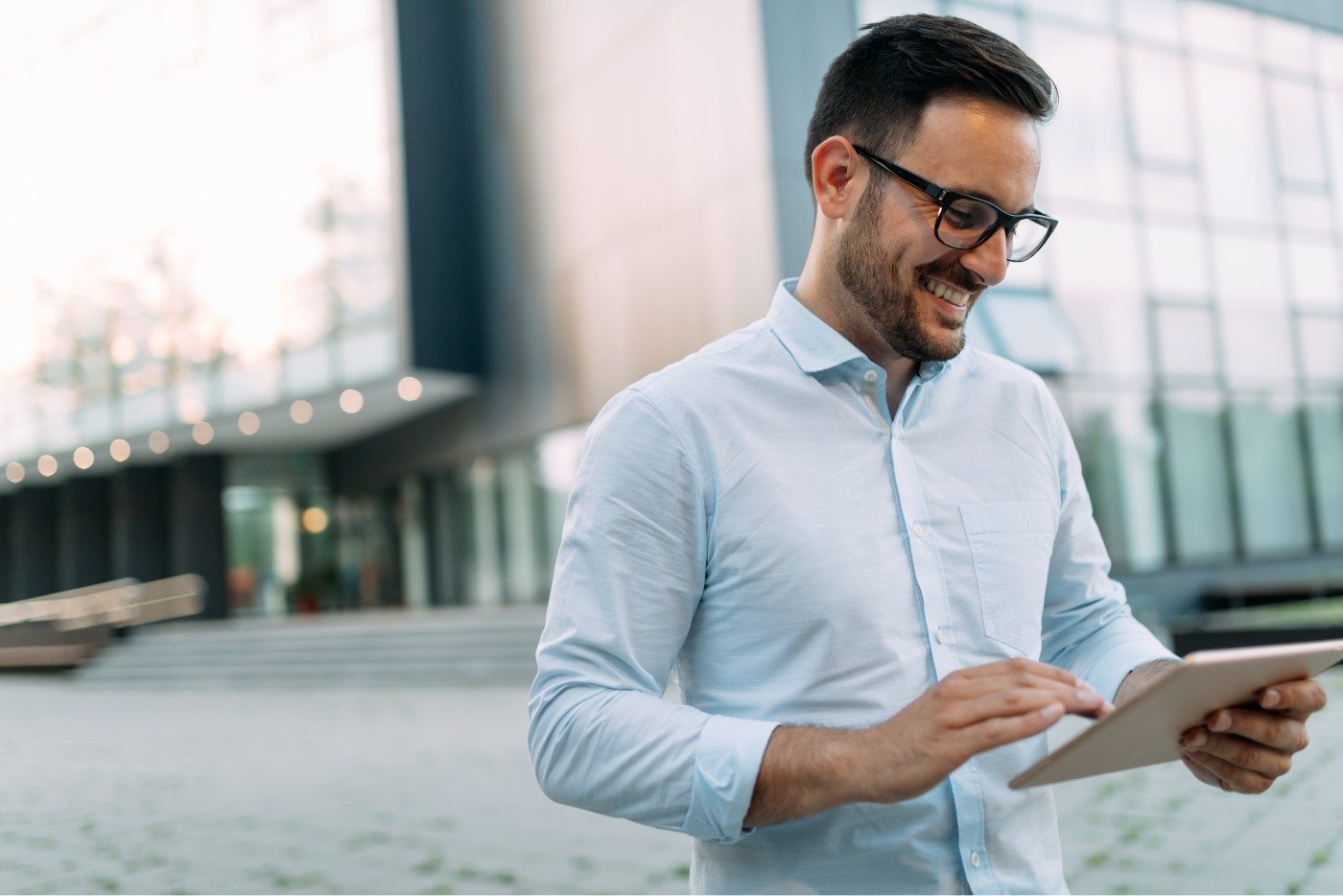 portrait-of-businessman-in-glasses-holding-tablet-AWVHCJU